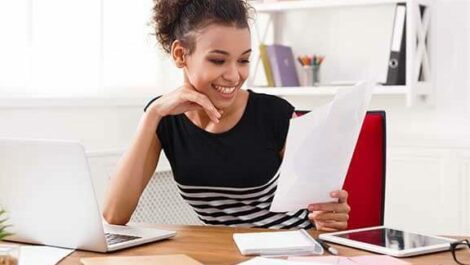 Woman working at a desk with a laptop.