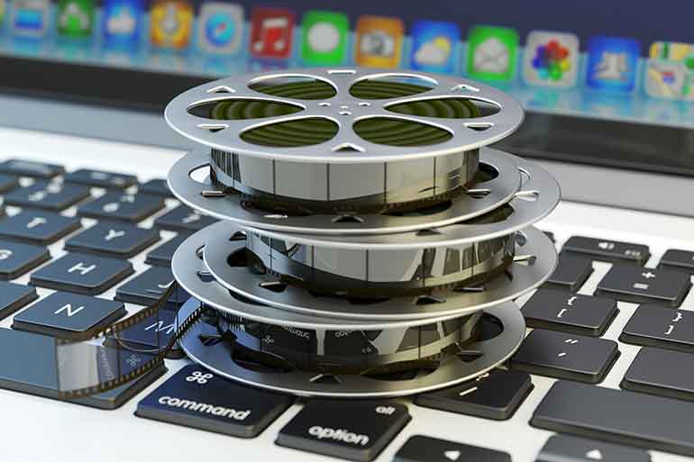 old film reels on top of a laptop keyboard