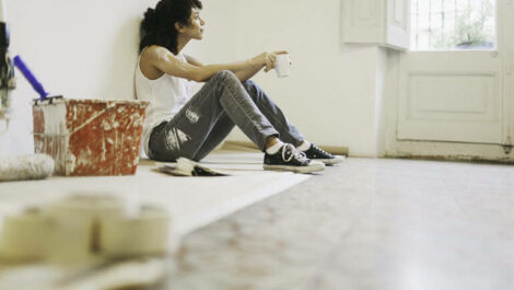 Woman taking a break from painting her wall.