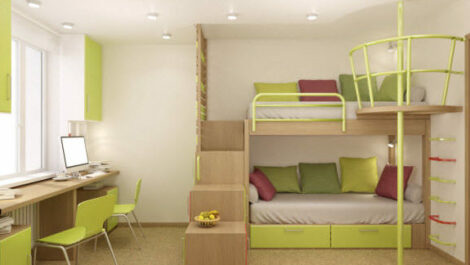 A green and white dorm room with bunked beds and a desk set up