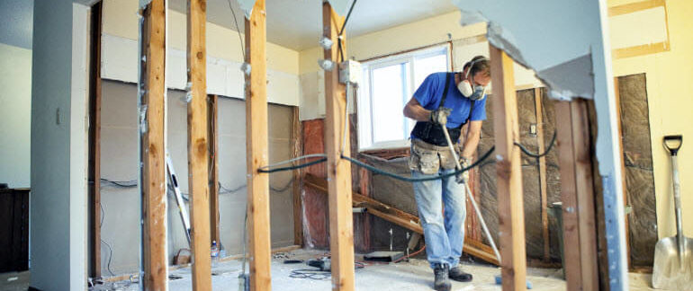 A man in a respirator renovating a house.