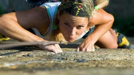 Woman climbing a cliff.