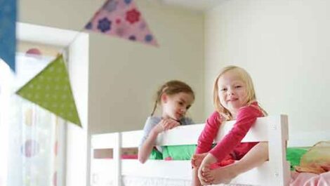 Little girls sitting in a bed.