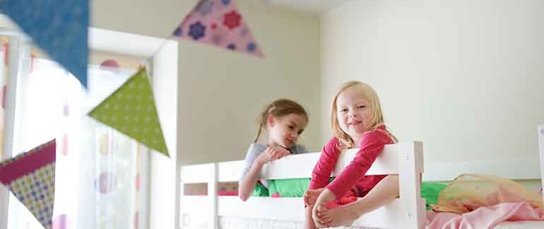 Little girls sitting in a bed.