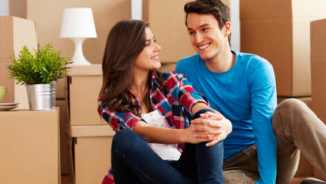 Couple sitting in front of moving boxes.