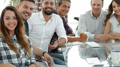 Friends sitting at a desk.