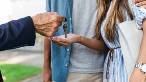 Realtor handing couple the keys to their new home.