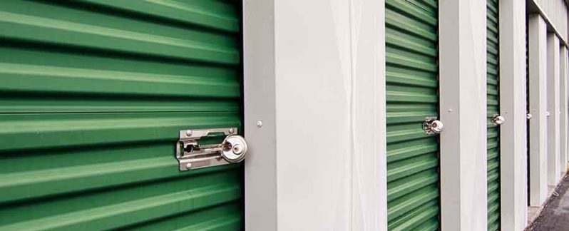 a row of green self storage garage doors with locks installed