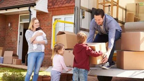 A family around a moving truck full of boxes.