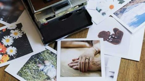 Polaroid camera surrounded by Polaroid images.