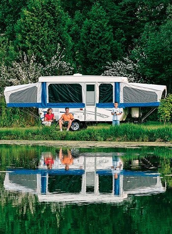 Family fishing outside of a popup RV.