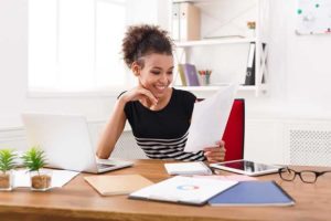 happy black woman working in home office on laptop
