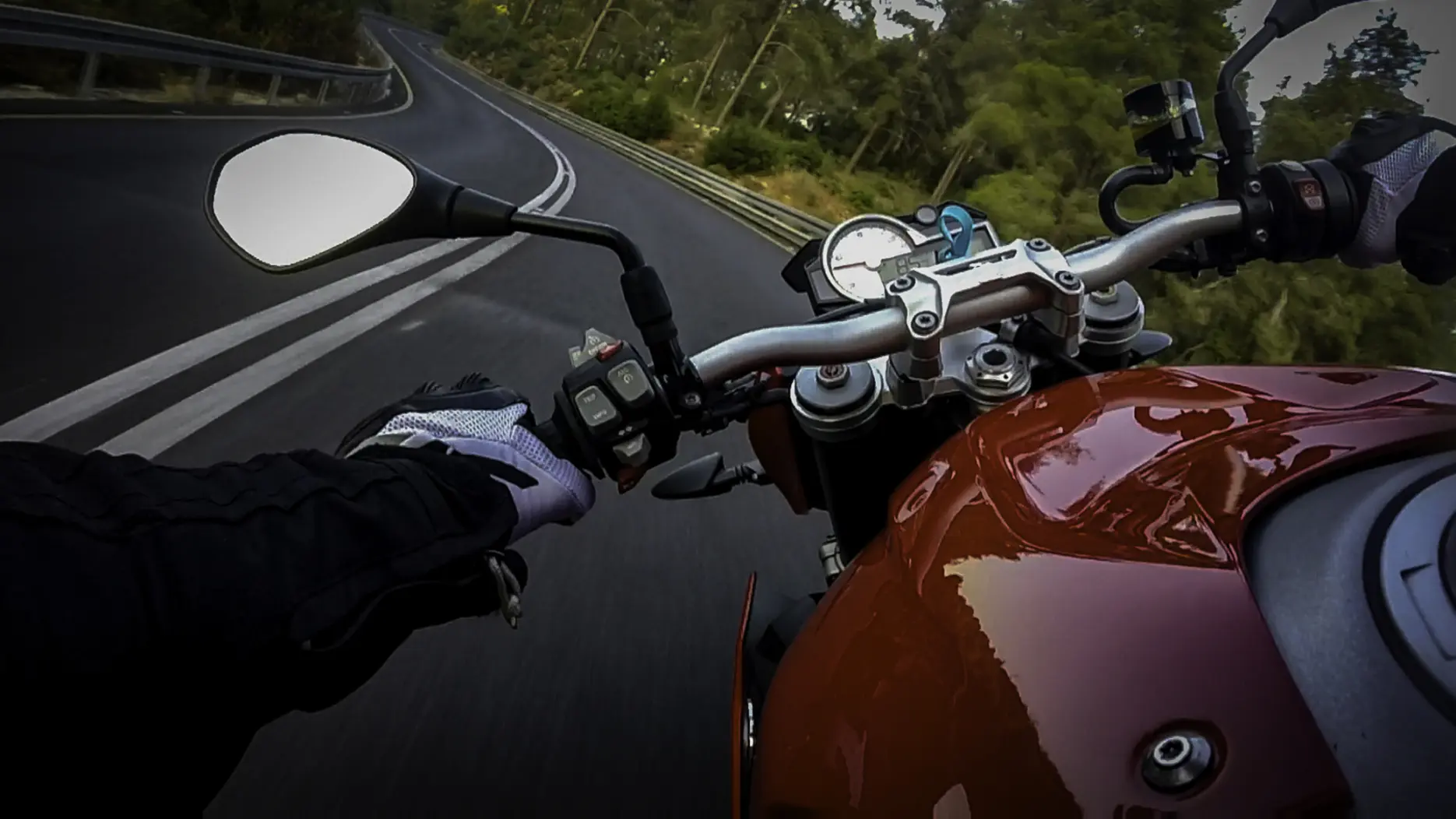 POV of motorcyclist driving down a winding highway. 