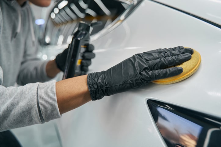 Man waxing his car in the garage.