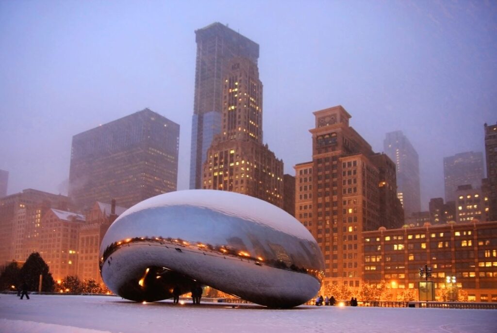 Snowy, winter view of The Bean located in Millennium Park, the lakefront park in Chicago's downtown Loop.