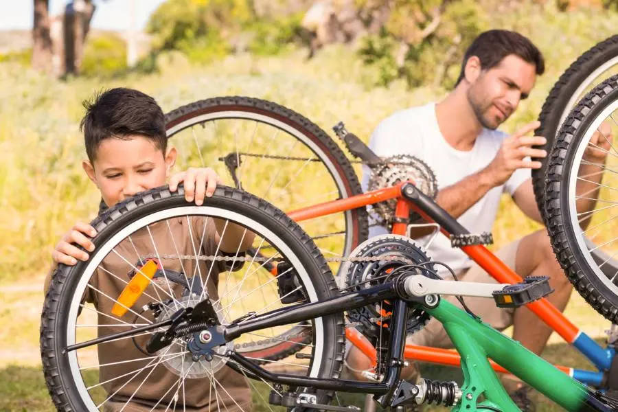 A father and son inspecting their bikes together