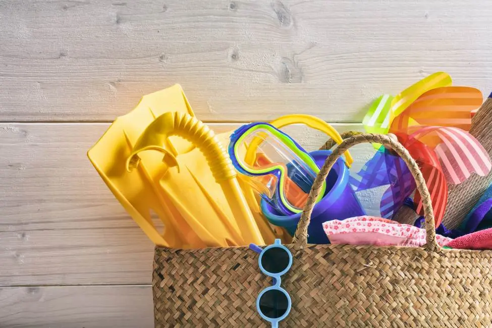 Snorkeling gear, beach toys, and other summer items stored in a straw bag