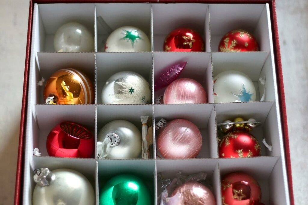 Colorful Christmas ornaments carefully stored in a box with dividers.