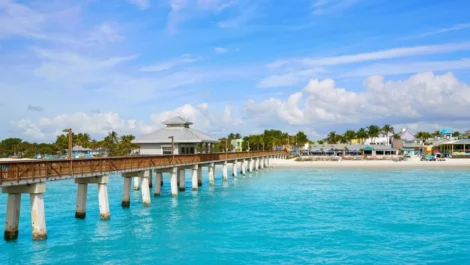 A dock extends into an ocean full of bright blue water