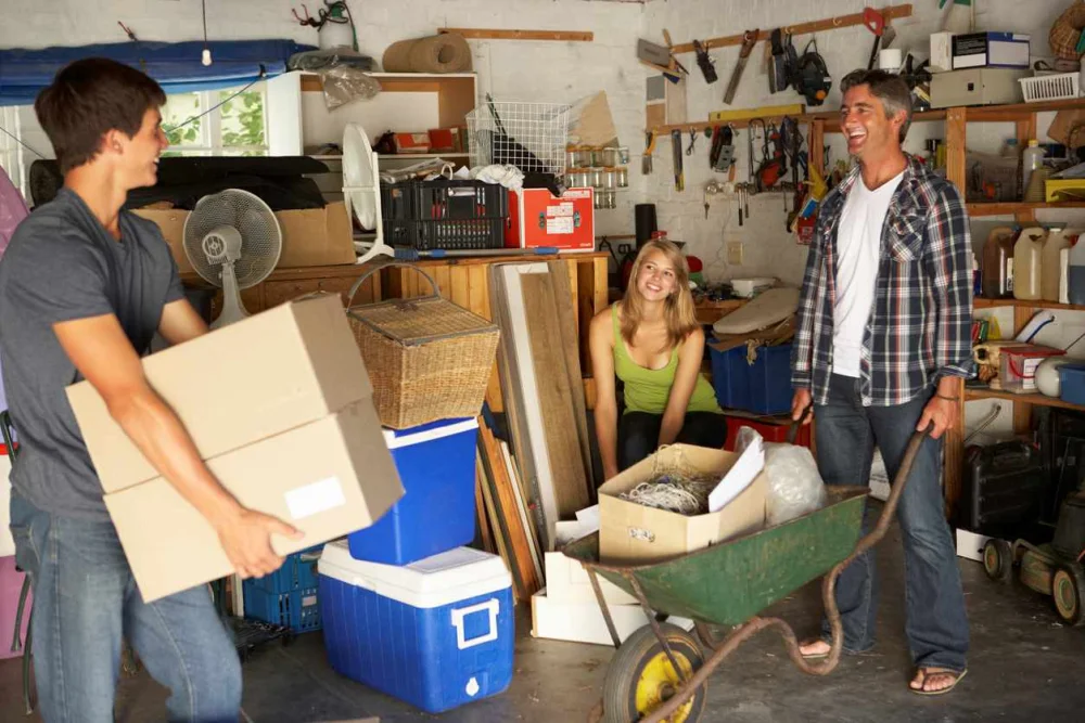 Father and teenage son and daughter laugh while organizing the garage