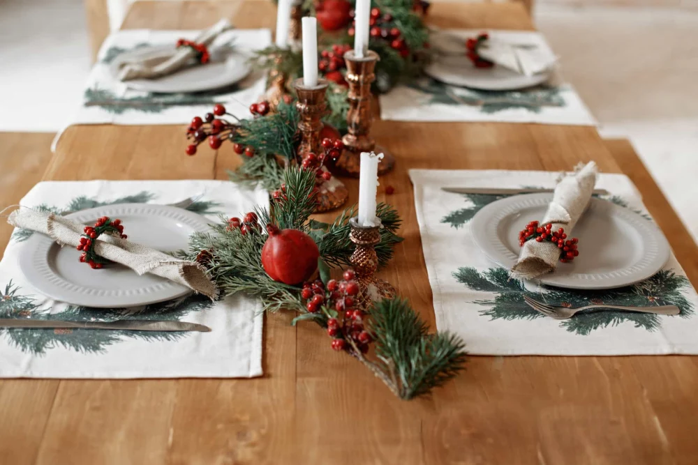 A table decorated with christmas themed place settings.