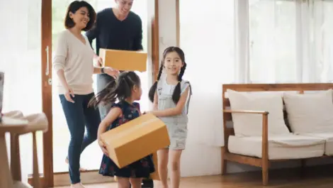 Young Asian family with daughter holds carton and walking in to a new home in moving relocation day which Excited smiling and felling happy.