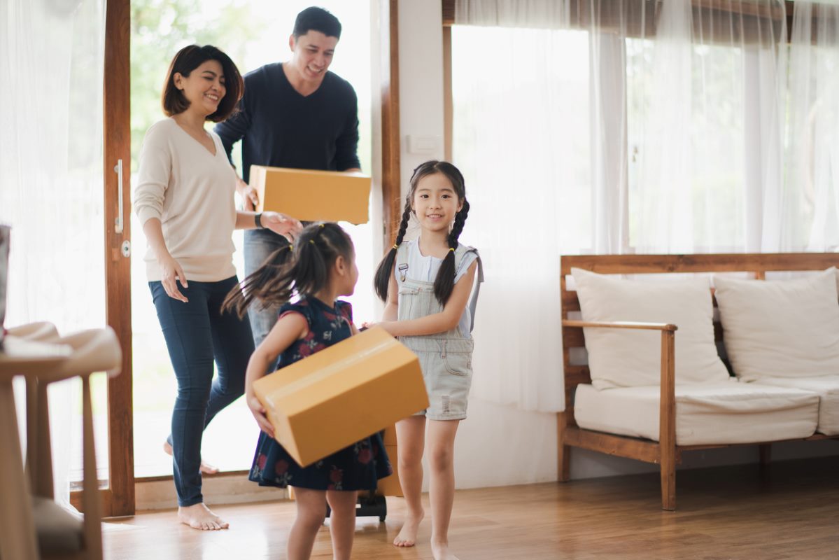 Young Asian family with daughter holds carton and walking in to a new home in moving relocation day which Excited smiling and felling happy.