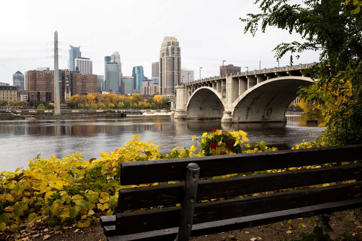 Riverfront view of downtown Minneapolis with bridge in sight.