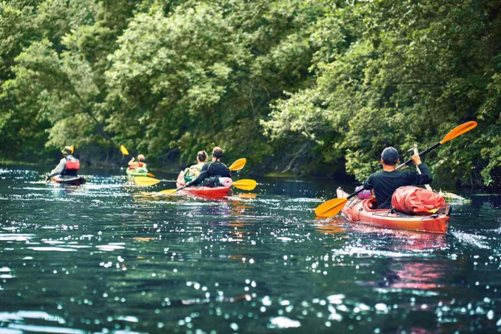 friends having fun on floating down a river on kayaks.