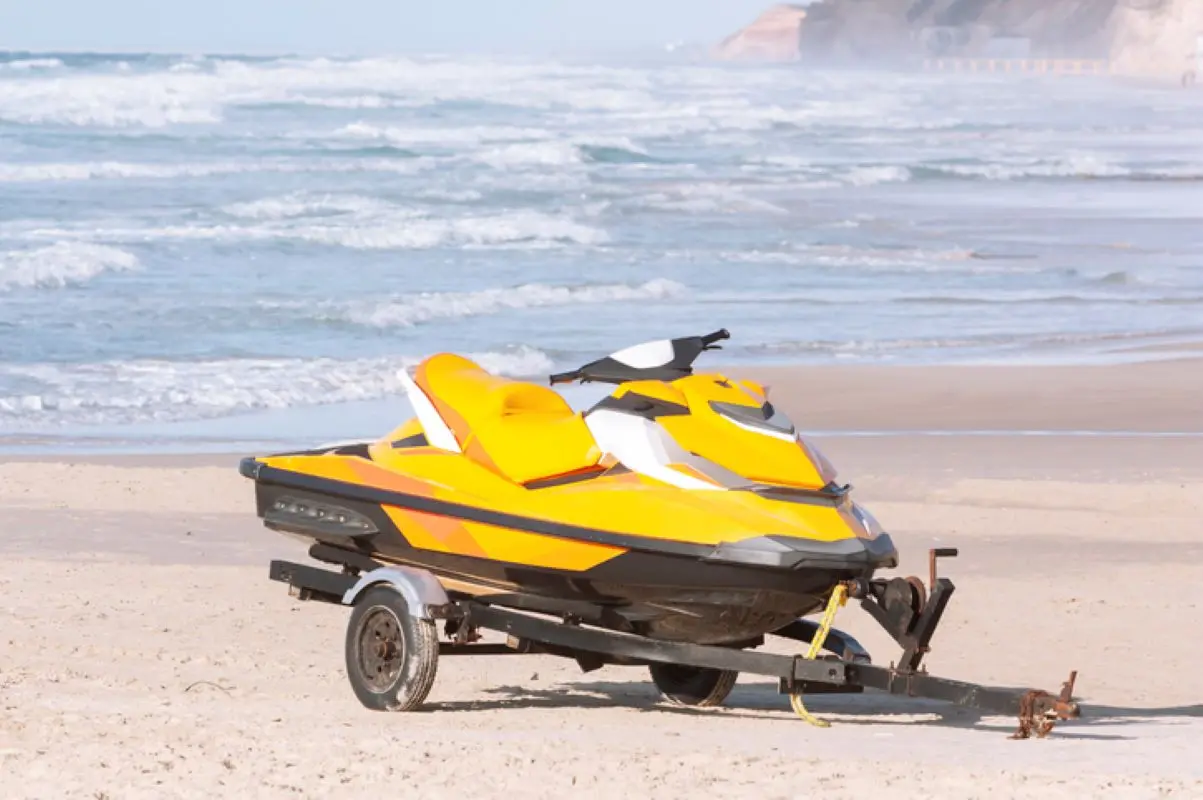 Jetski parked in the sand next to a beach.