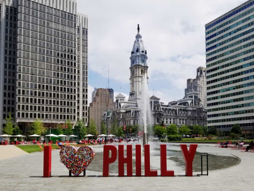 I Heart Philly sign with City Hall in the background at the corner of Market St and Broad St downtown Philly