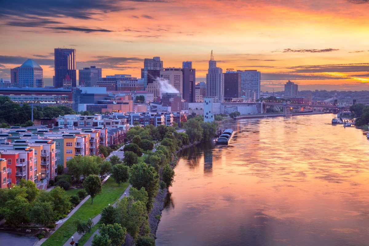 Aerial cityscape image of downtown St. Paul, Minnesota, USA with reflection of the skyline in Mississippi River at beautiful summer sunrise.