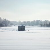 Ice fishing shelters at a Minnesota lake during a bright winter morning.