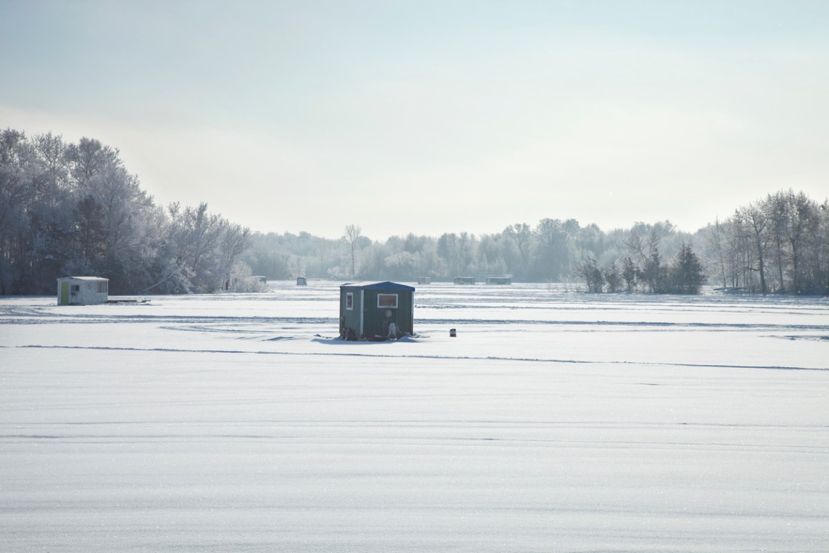 Ice fishing shelters at a Minnesota lake during a bright winter morning.