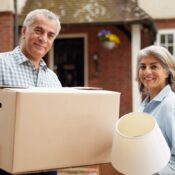 Older couple moving boxes into a storage unit as they are downsizing.