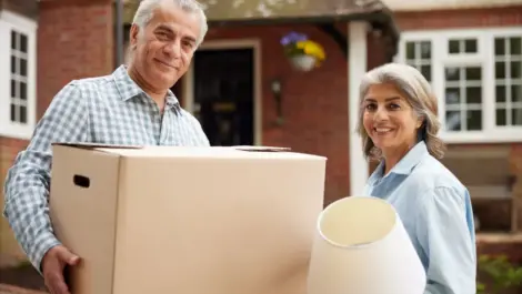 Older couple moving boxes into a storage unit as they are downsizing.