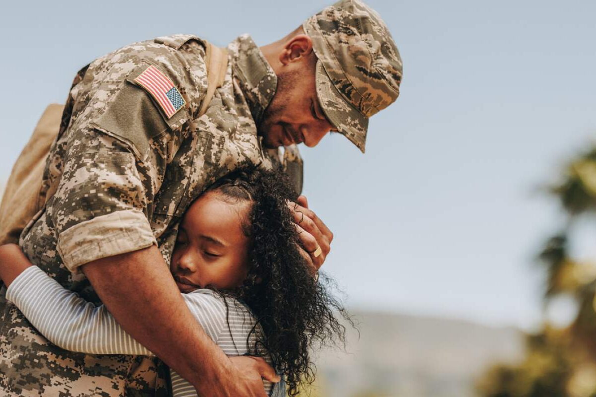 A soldier hugs his daughter as he prepares to leave for a deployment.