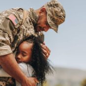 A soldier hugs his daughter as he prepares to leave for a deployment.