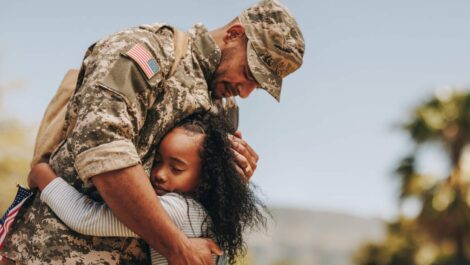 A soldier hugs his daughter as he prepares to leave for a deployment.